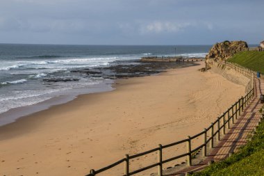 Tahta çitler Bluff Beach 'teki kum ve geçidi ayırıyor, Durban.