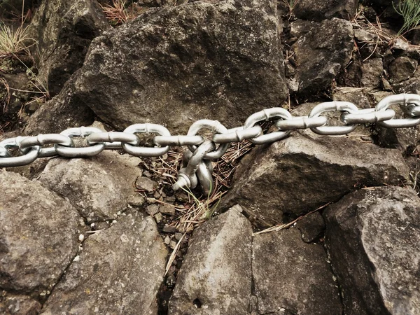 Eye bolt with iron chain anchored into sandstone rock. Twisted chain — Stock Photo, Image