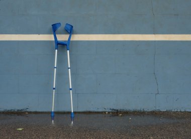 Açık stadyum oyuncuları kortmavi eğitim tenis duvarında Tıbbi koltuk değneği, arkasında eski çatlak boya 