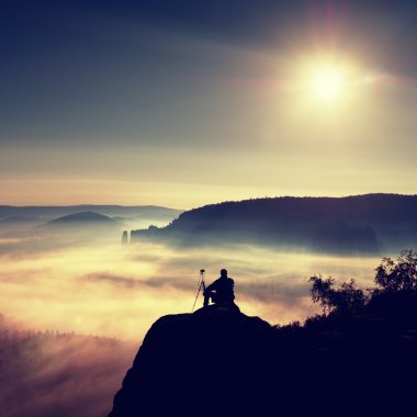 Fotoğrafçı ile tripod ve fotoğraf makinesi cliff ve düşünme. Rüya gibi adamlara manzara