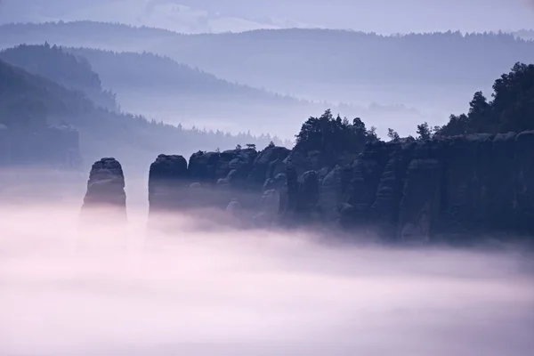 Roze mist in berg land. Scherpe rotsen romige mist op reepjes gesneden. — Stockfoto