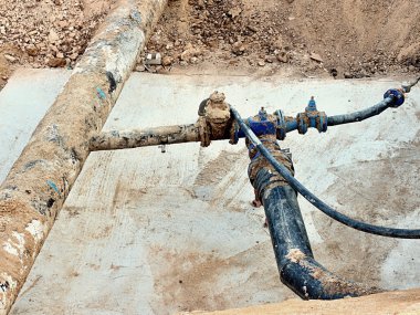 Kazı çukuru. Eski 500mm içecek su boru 150mm viraj kolu ile gate vanalar, aşınmış bağlantı parçaları katılmadan. Tüpler onarım boru önce. Asfalt yalıtım. 