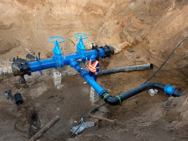Technical expert underground at gate valve on 500mm drink water pipes . Check of repaired piping before covering by clay. Asphalt isolation — Stockfoto