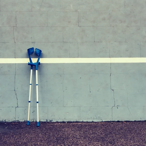 Deux béquilles médicales usagées au mur de tennis d'entraînement sur le terrain , — Photo