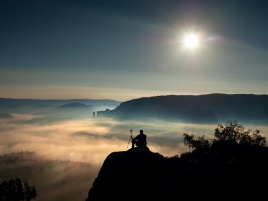 Fotoğrafçı ile tripod ve fotoğraf makinesi cliff ve düşünme. Rüya gibi adamlara manzara