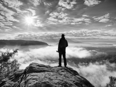 Fotoğrafçı ile folden tripod cliff düşünme ucunda. Puslu manzara