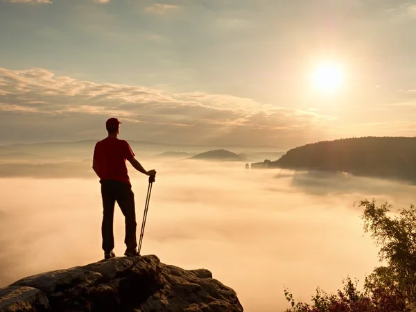 Turistovi turistické hole stojí na útesu na vřes bush na vrcholu skály — Stock fotografie