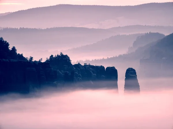 Mistige melancholie daybreak in mooie fee vallei. Pieken van rock trim romige mistige wolken — Stockfoto