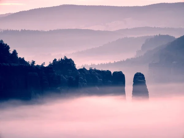 Amanecer melancólico brumoso en el hermoso valle de hadas. Picos de roca recortar cremosas nubes de niebla — Foto de Stock