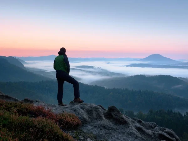 Caminhante homem no rock relógio sobre mista cremoso e nevoeiro paisagem matinal . — Fotografia de Stock