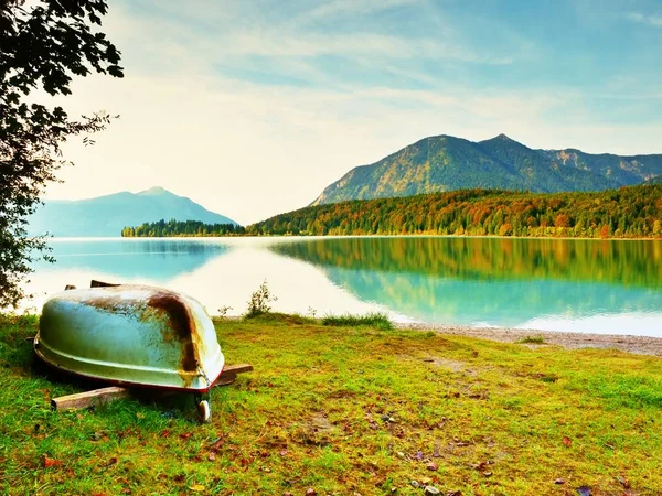 Upside down  fishing paddle boat on bank of Alps lake. Morning autumnal lake. — Stock Photo, Image