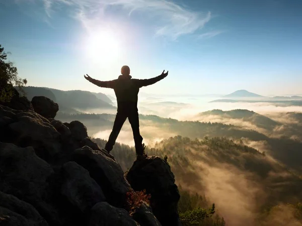 Solig höst morgon. Glada vandrare med upphöjda händer i luften stå på rock — Stockfoto