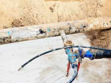 Kazı çukuru. Eski 500mm içecek su boru 150mm viraj kolu ile gate vanalar, aşınmış bağlantı parçaları katılmadan. Tüpler onarım boru önce. Asfalt yalıtım. 