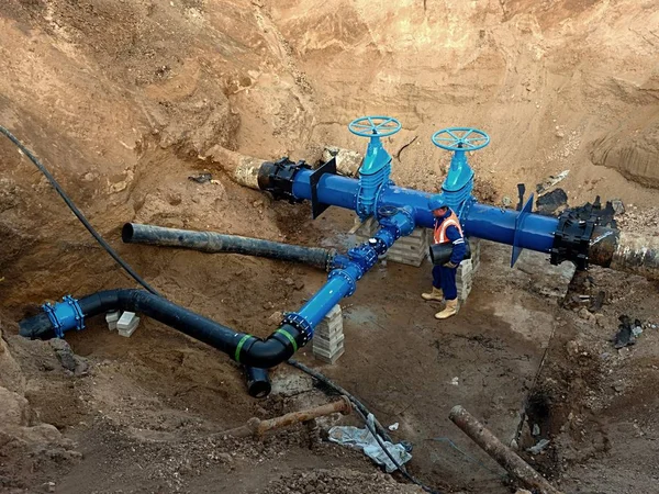 Trabajador subterráneo en la válvula de compuerta en el sistema de agua potable, waga varios miembros conjuntos . — Foto de Stock