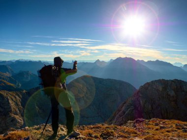 Lens flare kusur. Uzun yürüyüşe çıkan kimse selfie fotoğrafı çeker. Adam büyük sırt çantası ile