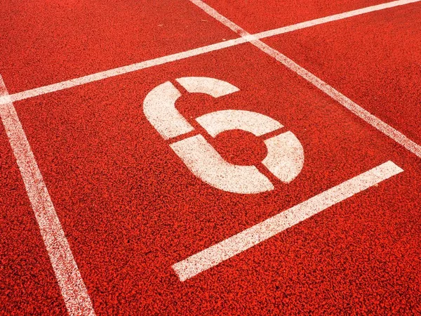 Nummer sex. Vit athletic spårnummer på röd gummi travet — Stockfoto
