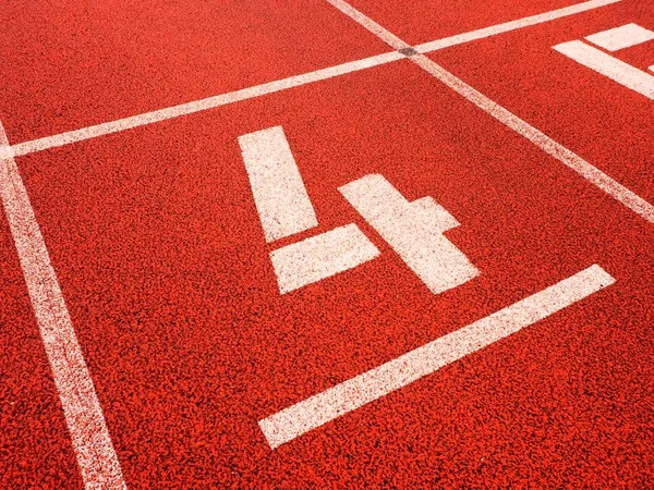 Number four. White track number on red rubber racetrack, — Stock Photo, Image
