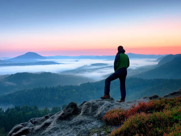 Caminhante homem no rock relógio sobre mista cremoso e nevoeiro paisagem matinal . — Fotografia de Stock