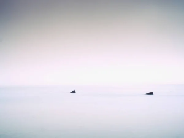 Tramonto rosa sulla costa rocciosa del mare. Livello dell'acqua liscio ed effetto sognante — Foto Stock