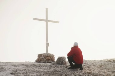Ağır Sis memorial dağ tepe üzerine çapraz turist. Adam puslu dağ Vadisi feryat izliyor. Bir dağ tepe metal çapraz.