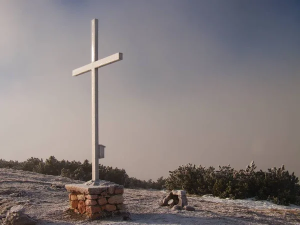 IJzeren Kruis op de bergtop in alp. Kruis op de top van een piek van de bergen als typisch in de Alpen. Monument voor de dode klimmers. Verse sneeuw na winderig en diepe bevriezen nacht. — Stockfoto