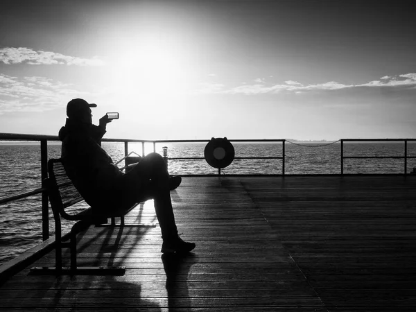 관광은 두더지에 강철 벤치에 앉아서 selfie 걸릴. 혼자 남자는 바다에서 안개 낀 아침을 즐길 수 — 스톡 사진