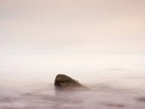 Romantische zee. Boulder stok uit uit glad golvende zee. — Stockfoto