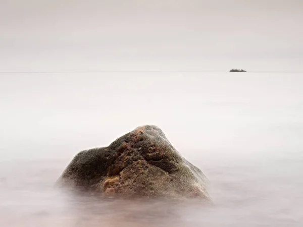 Manhã romântica no mar. Pedras grandes que se destacam do mar ondulado liso. Horizonte rosa com primeiros raios de sol quentes. Efeito estilo vintage — Fotografia de Stock