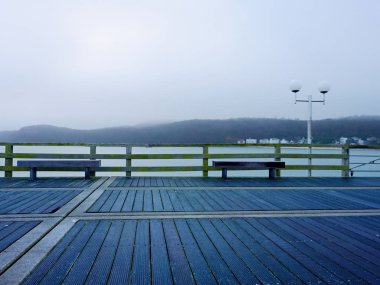 Deniz üstünde ahşap iskele sonbahar sisli sabahı. Depresyon, karanlık atmosfer.