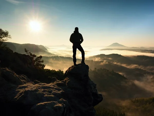 Mann auf dem Gipfel des Berges. Wanderer erklomm Felsgipfel über nebligem Tal. — Stockfoto