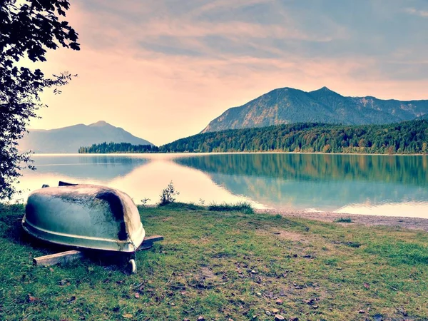 Upside down  fishing paddle boat on bank of Alps lake. Morning autumnal lake. — Stock Photo, Image