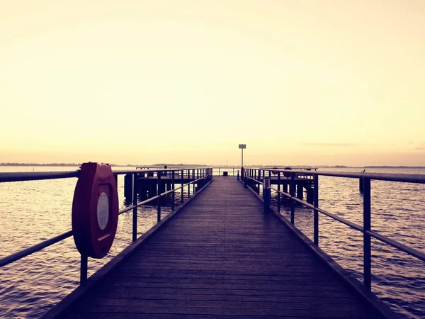 Lange houten pier aan de Baltische kust tijdens herfst ochtend. Koud weer — Stockfoto