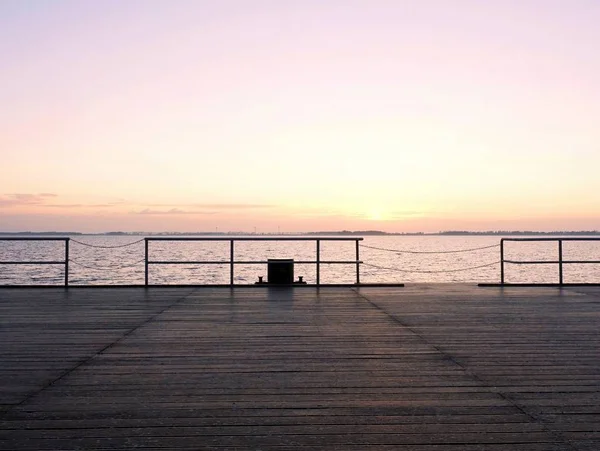 Pont maritime en bois vide. La façon de voir le lever du soleil au-dessus de l'horizon marin — Photo