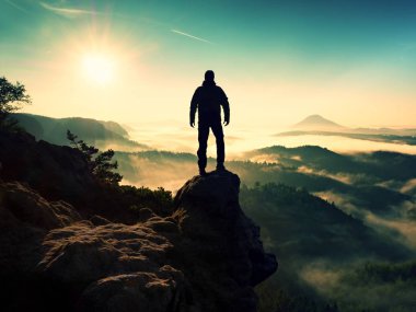 Adam siluet keskin rock tepe üzerinde kalmak. Uzun yürüyüşe çıkan kimse tatmin manzarasının tadını çıkarın.