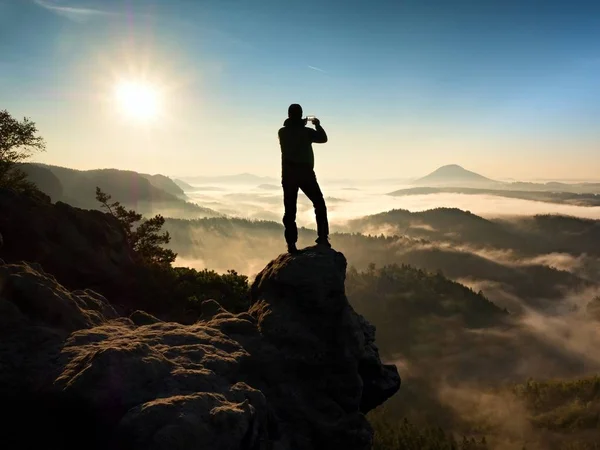 Tourist fotografiert mit Smartphone auf Gipfel der hügeligen Landschaft. Nebelschwaden im Herbst — Stockfoto