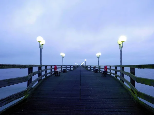 Mroczne mgły jesienią na drewnianym molo nad morzem. Depresja, mroczną atmosferę. — Zdjęcie stockowe