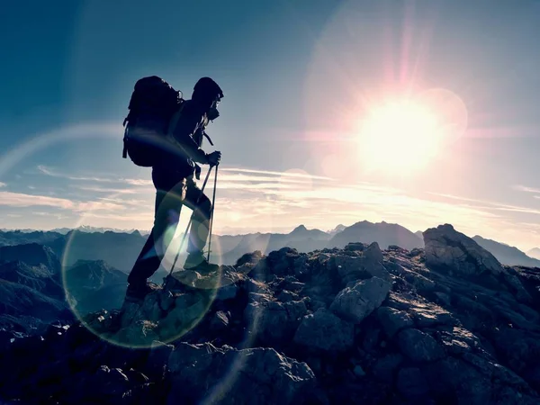 Lens flare defect.  Tourist guide on trekking path  with poles and backpack.  Experienced hiker — Stock Photo, Image