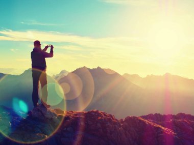 Mercek parlaması. Uzun yürüyüşe çıkan kimse selfie fotoğrafı çeker. Turistik zirve