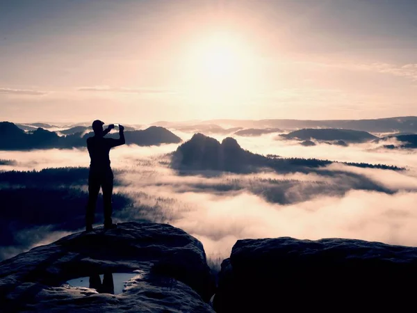 Wanderer Silhouette stehen auf Felsen und wachen über neblige Tal zur Sonne. blauer Filter — Stockfoto