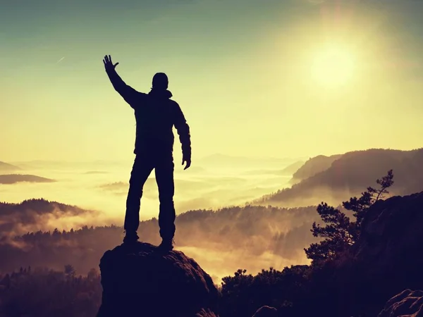 Ο άνθρωπος στέκεται ψηλά στον βράχο. Πεζοπόρος σκαρφάλωσε μέχρι την βραχώδη κορυφή και απολαύστε θέα — Φωτογραφία Αρχείου