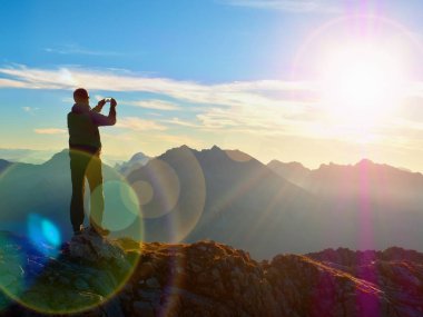 Mercek parlaması. Uzun yürüyüşe çıkan kimse selfie fotoğrafı çeker. Turistik zirve