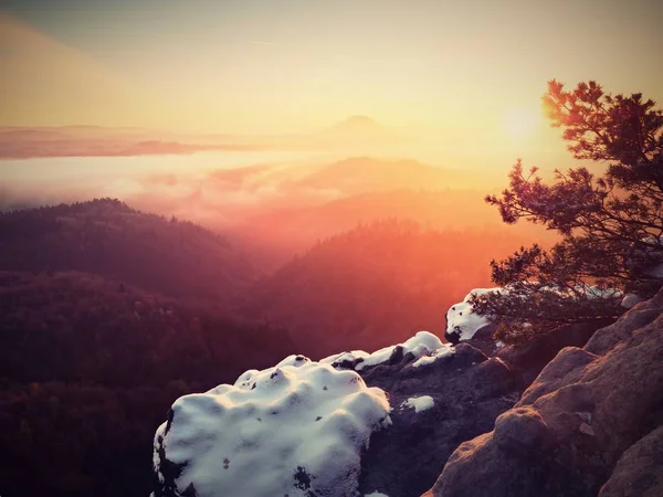 Première couverture de neige poudreuse sur des rochers de grès au-dessus de la vallée. Brume épaisse — Photo