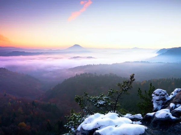 Première couverture de neige poudreuse sur des rochers de grès au-dessus de la vallée. Brume épaisse — Photo