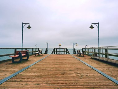 Seaside teleskop. Ahşap iskele sisli sonbahar sabahı 