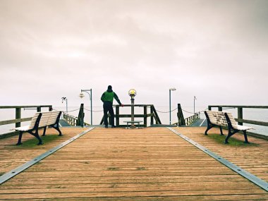 Harbor sonbahar sisli gün içinde ahşap köstebek adam. Küpeşte, turizm.