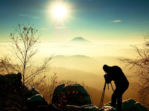 Fotógrafo tira foto de pedras congeladas cobertas com neve fresca em pó . — Fotografia de Stock