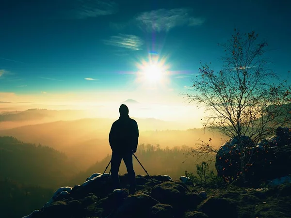 Fotograf fotografiert gefrorene Felsen, die mit frischem Pulverschnee bedeckt sind. — Stockfoto