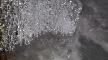 Soğuk su kış dağ nehir üzerinde asılı shinning buz sarkıtları detayını. Köpüklü akış yukarıda ışıltılı buz sarkıtları. Buz örtüsünün ve küçük gevreği toz kar düşmüş gövdeleri