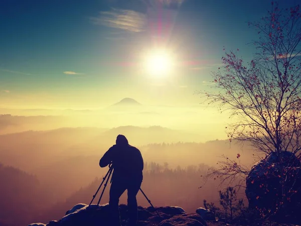 Fotograf fotografiert gefrorene Felsen, die mit frischem Pulverschnee bedeckt sind. — Stockfoto