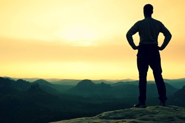 Güneşli sonbahar sabah. Uzun yürüyüşe çıkan kimse kayalık dağ tepe üzerinde duruyor